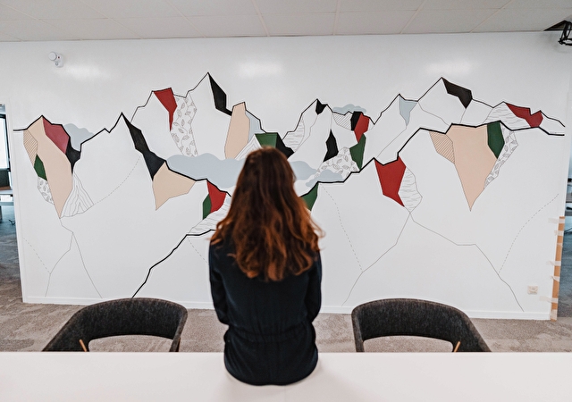 Maeva Revellin devant sa fresque chez HP à Grenoble